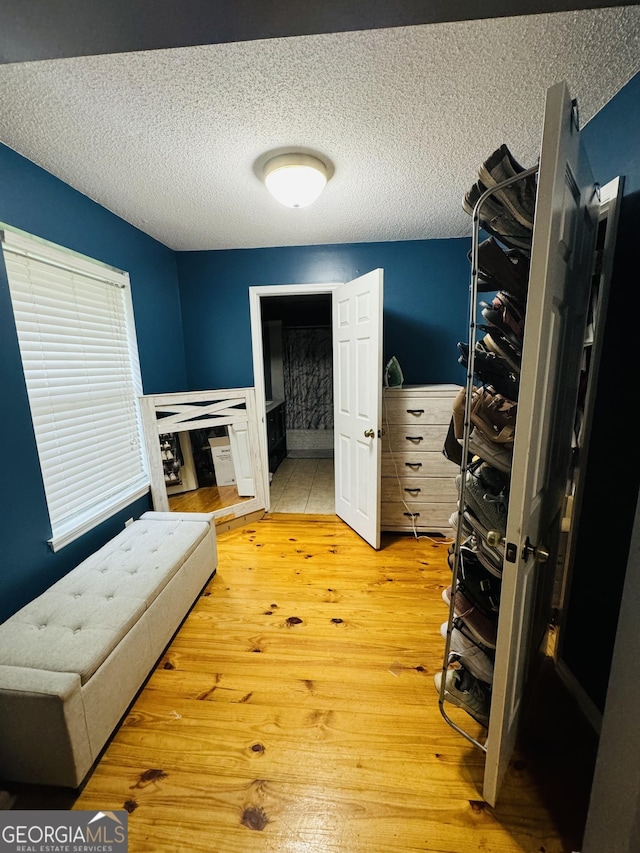 interior space with a textured ceiling and light wood-style flooring