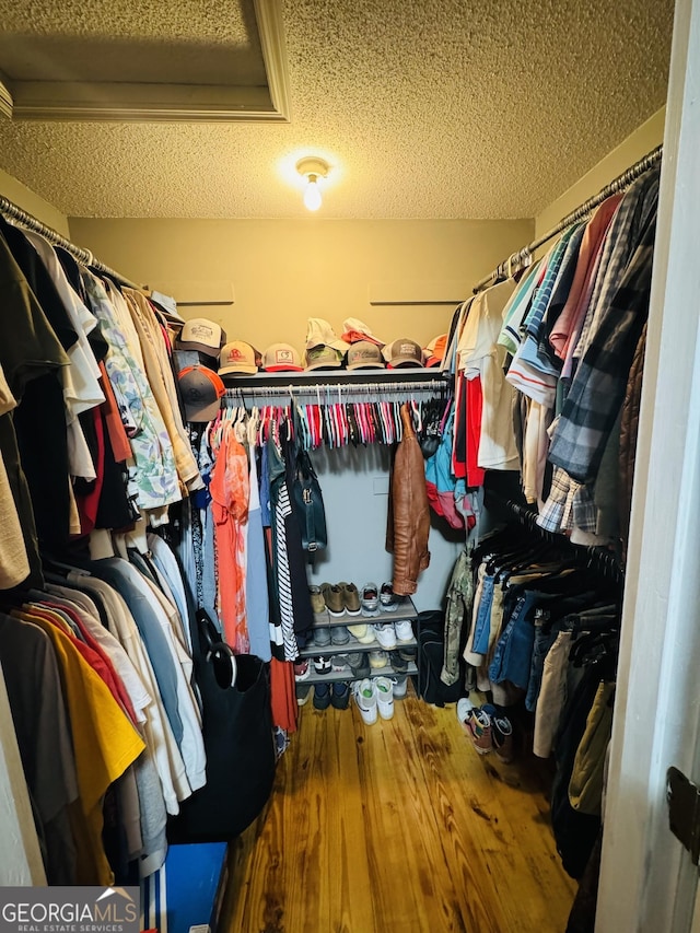 walk in closet with wood finished floors