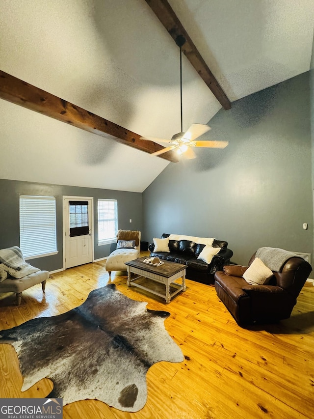 living room with vaulted ceiling with beams, a textured ceiling, a ceiling fan, and hardwood / wood-style floors