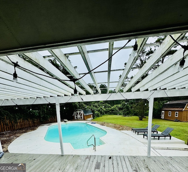 outdoor pool with an outbuilding, a deck, a lawn, and a pergola