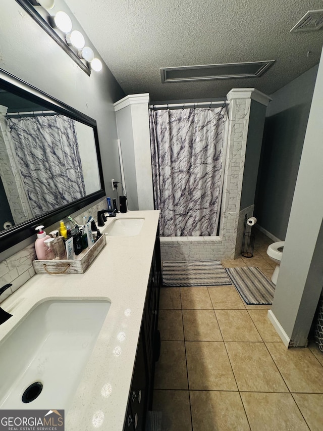 full bath featuring a textured ceiling, a sink, visible vents, and tile patterned floors