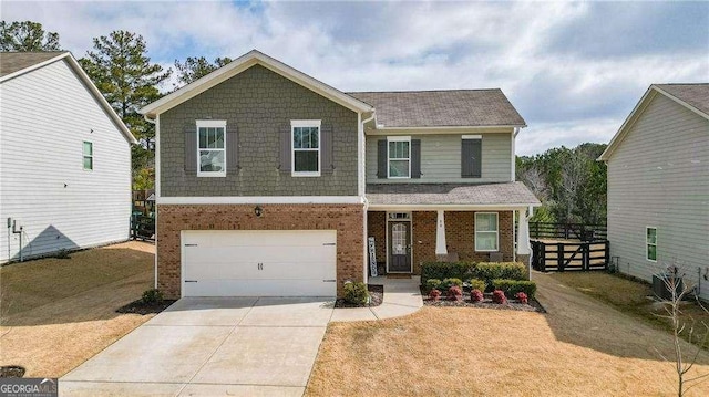 view of front facade with driveway, a garage, fence, and brick siding