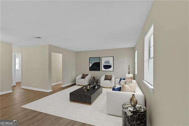 living area featuring baseboards and wood finished floors