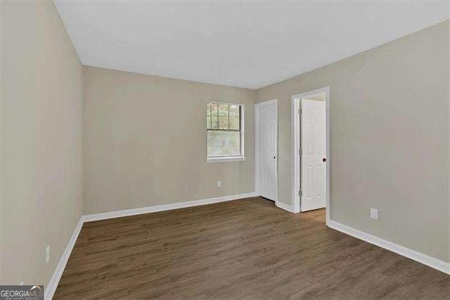 unfurnished bedroom with wood finished floors and baseboards