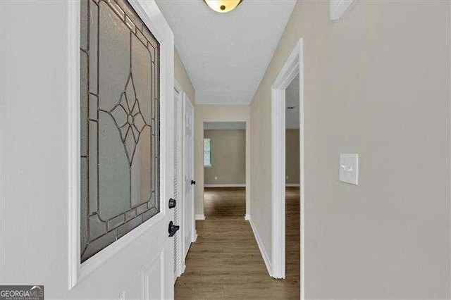 hall featuring baseboards and wood finished floors