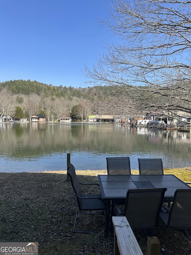 view of dock featuring a water view and outdoor dining space