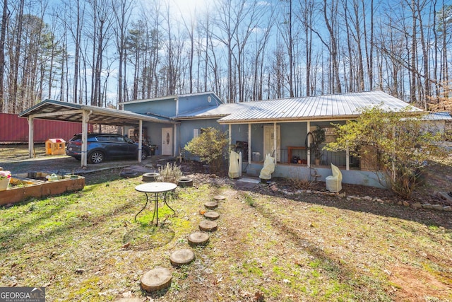 view of front of property with metal roof, a carport, and a sunroom