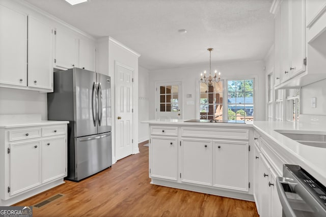 kitchen with light wood finished floors, visible vents, appliances with stainless steel finishes, white cabinetry, and a peninsula