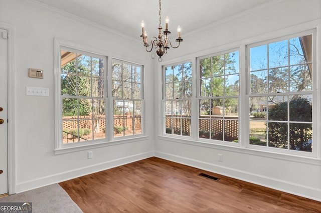 unfurnished sunroom with visible vents and a notable chandelier