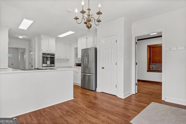 kitchen with crown molding, stainless steel appliances, wood finished floors, and white cabinets