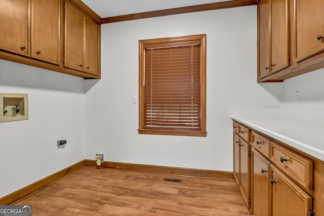 laundry room featuring cabinet space, visible vents, light wood-style flooring, ornamental molding, and washer hookup