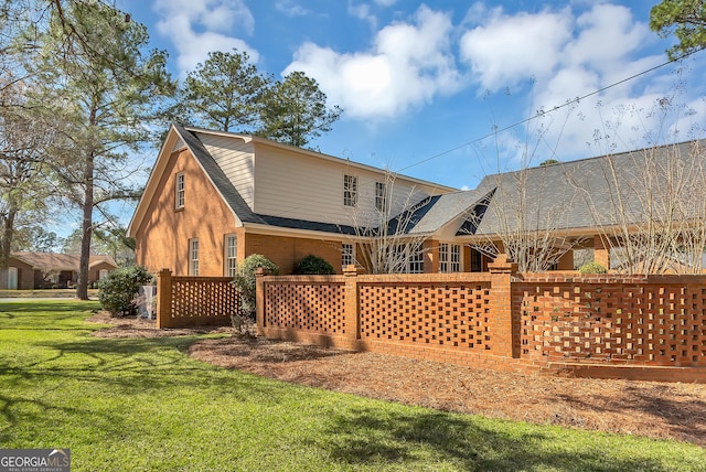 back of property with brick siding and a lawn