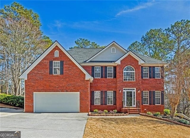 colonial-style house featuring concrete driveway, brick siding, an attached garage, and a front yard