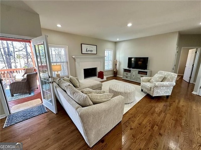 living area with dark wood-style floors, a fireplace, baseboards, and recessed lighting