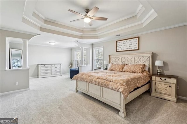 carpeted bedroom featuring crown molding, a raised ceiling, decorative columns, and baseboards