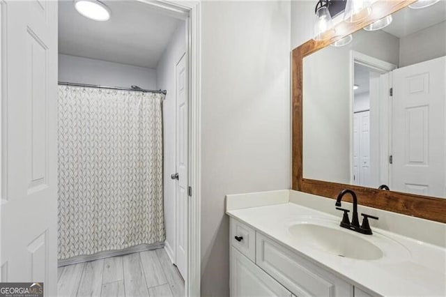 bathroom featuring curtained shower, wood finished floors, and vanity