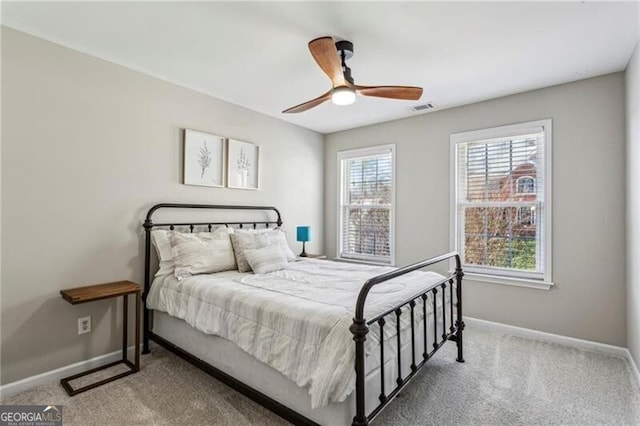 carpeted bedroom with visible vents, baseboards, and a ceiling fan