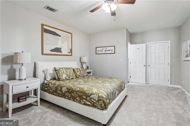 carpeted bedroom with a ceiling fan, a closet, visible vents, and baseboards