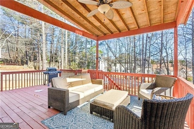 wooden deck featuring area for grilling, outdoor lounge area, and a ceiling fan