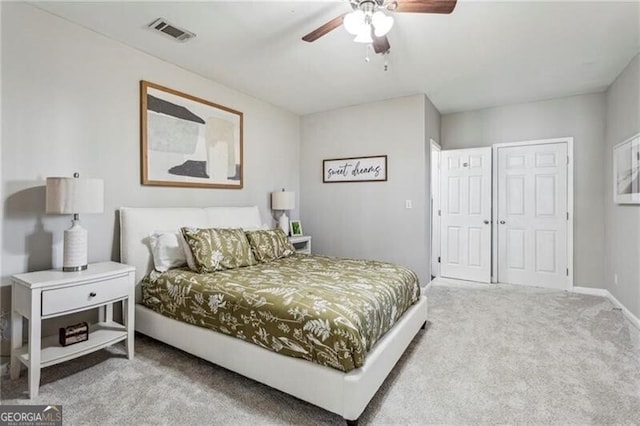 carpeted bedroom with visible vents, ceiling fan, a closet, and baseboards