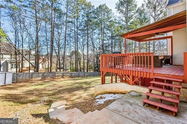 view of yard featuring an outbuilding, a fenced backyard, a deck, and a shed