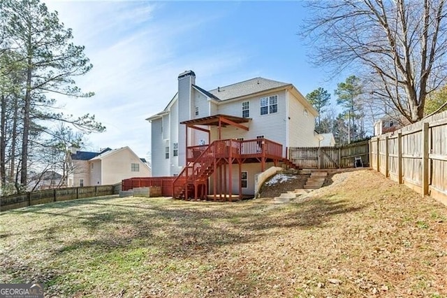 back of property featuring a fenced backyard, a lawn, stairway, a wooden deck, and a chimney