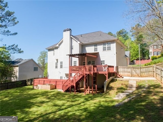 back of property with a wooden deck, a yard, a fenced backyard, stairway, and a chimney