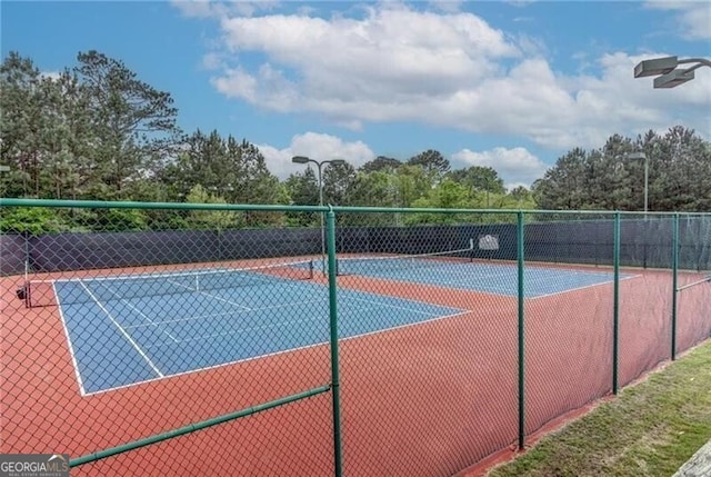 view of tennis court featuring fence