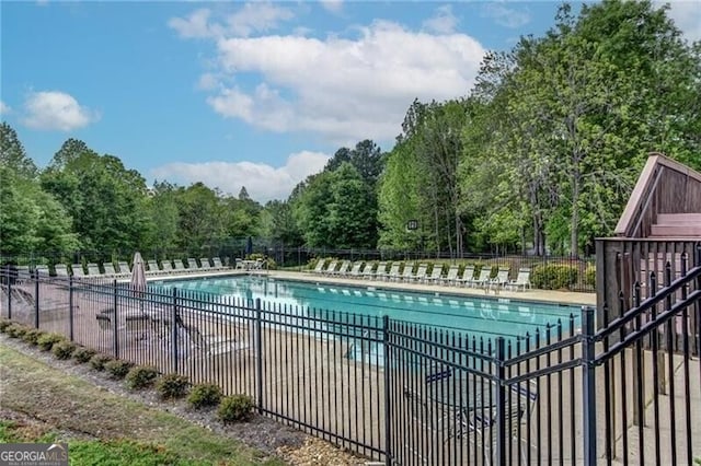 community pool with a patio and fence