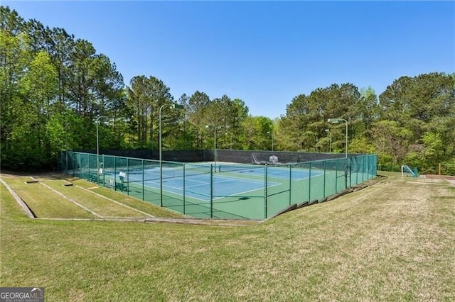 view of sport court featuring a yard and fence