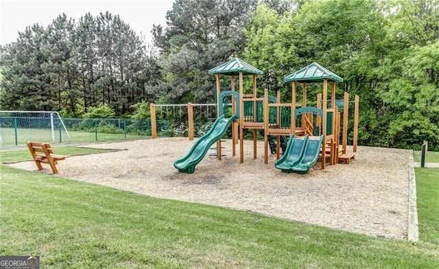 community jungle gym featuring a yard and fence