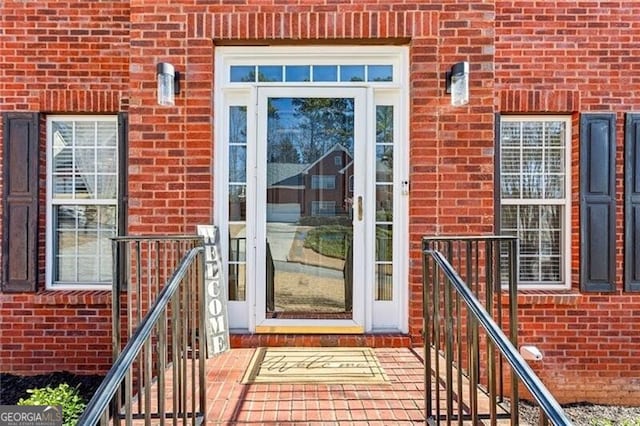 doorway to property featuring brick siding
