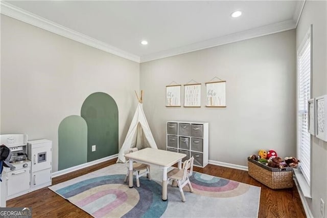 recreation room with ornamental molding, baseboards, recessed lighting, and wood finished floors