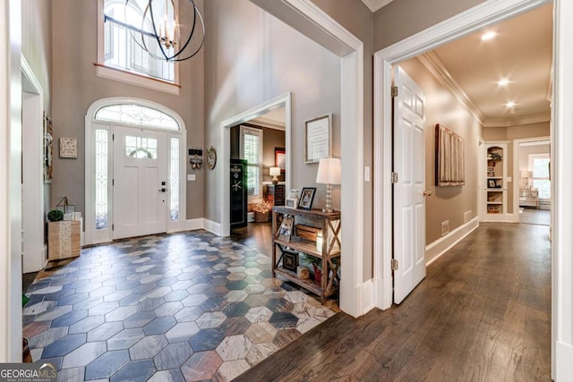 foyer entrance featuring recessed lighting, a notable chandelier, baseboards, ornamental molding, and dark wood-style floors