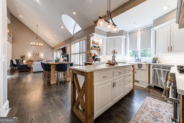 kitchen with decorative backsplash, stainless steel dishwasher, light countertops, and white cabinetry