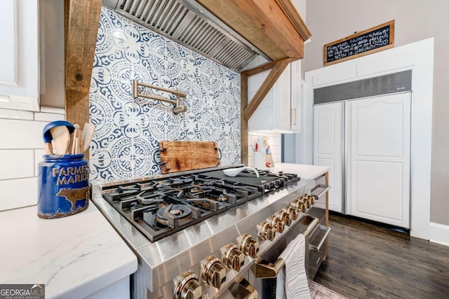 kitchen with white cabinets, dark wood-style flooring, tasteful backsplash, high end appliances, and premium range hood