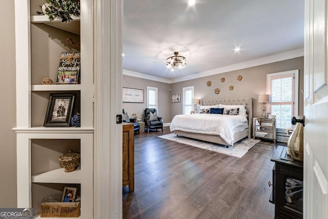 bedroom with dark wood finished floors and crown molding