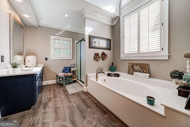 bathroom featuring a garden tub, crown molding, wood finished floors, and a shower stall