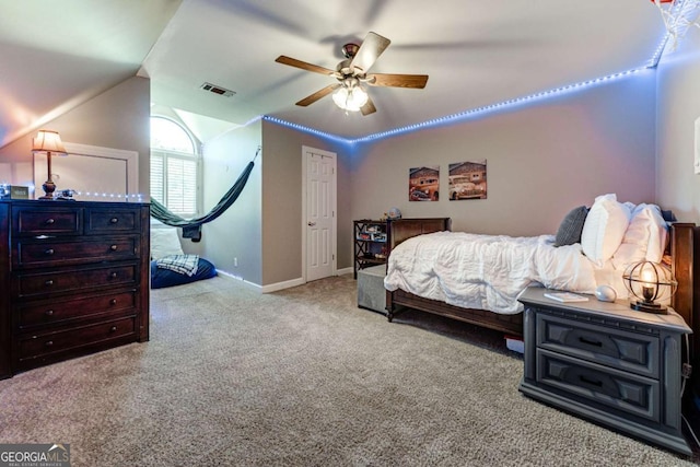 carpeted bedroom with ceiling fan, vaulted ceiling, visible vents, and baseboards