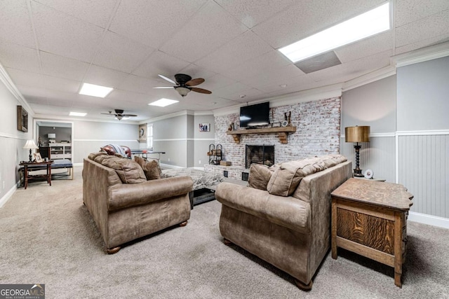 carpeted living area featuring ceiling fan, a brick fireplace, and ornamental molding
