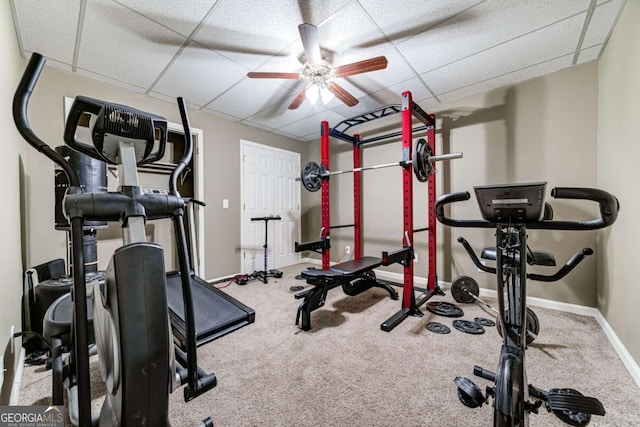 workout area featuring baseboards, a drop ceiling, ceiling fan, and carpet flooring