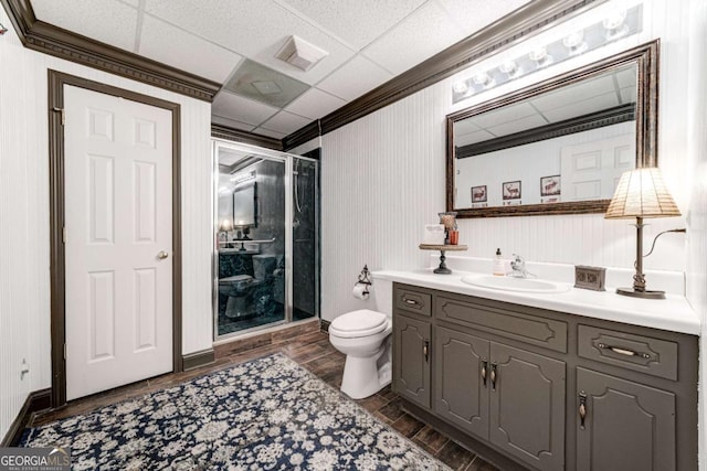 full bath with toilet, ornamental molding, a shower stall, vanity, and wood finished floors