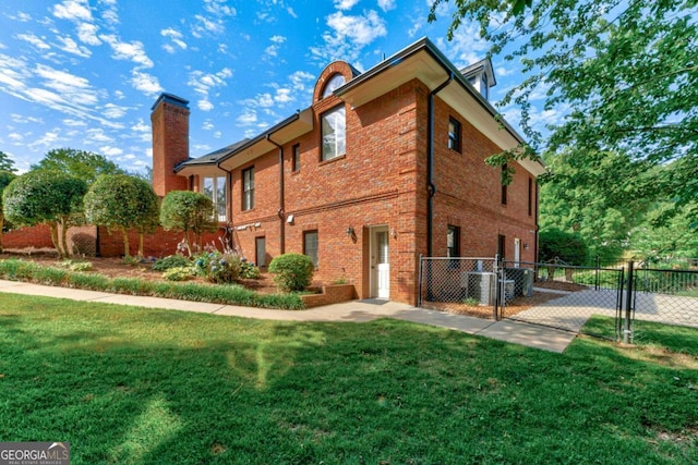 rear view of property with fence, a chimney, a gate, and a yard