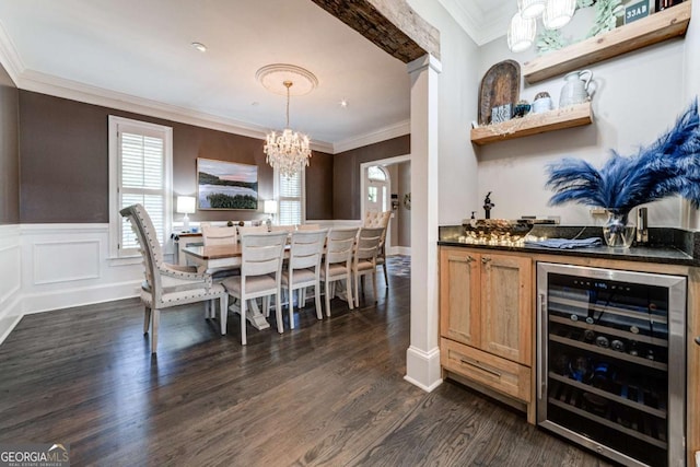 dining space with indoor bar, wine cooler, dark wood-style floors, an inviting chandelier, and crown molding