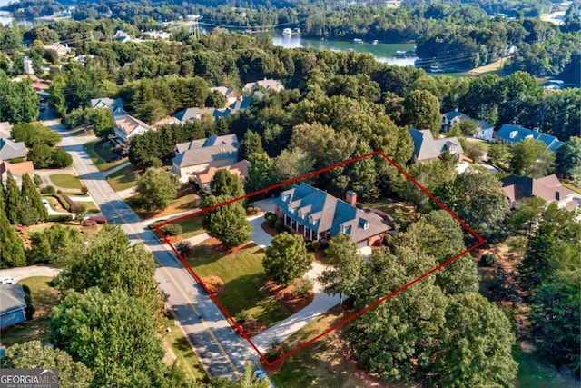 drone / aerial view featuring a water view and a wooded view