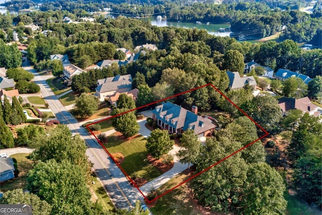 birds eye view of property with a forest view and a water view