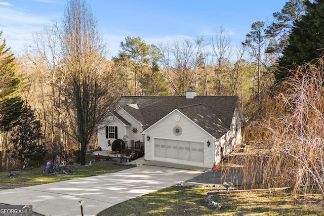 view of front of property with a garage, concrete driveway, and a chimney