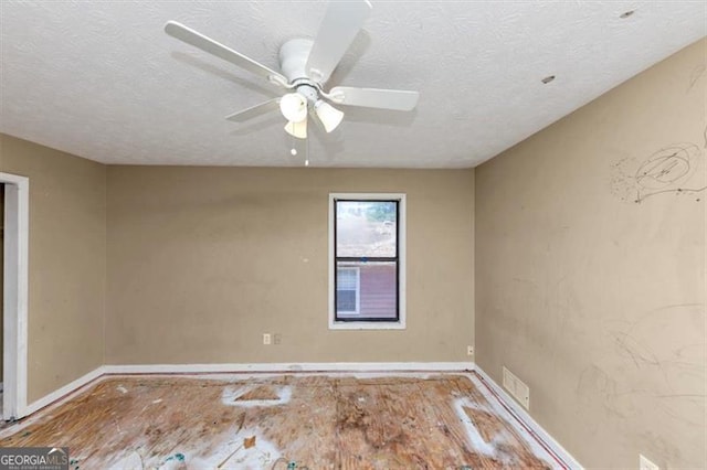 empty room featuring visible vents, ceiling fan, and a textured ceiling