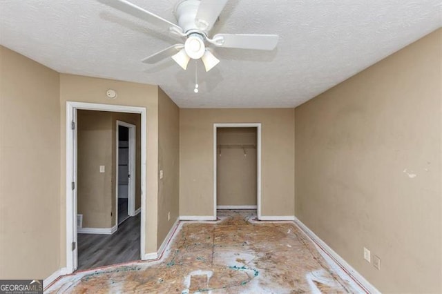 unfurnished bedroom featuring a textured ceiling, a closet, a ceiling fan, and baseboards