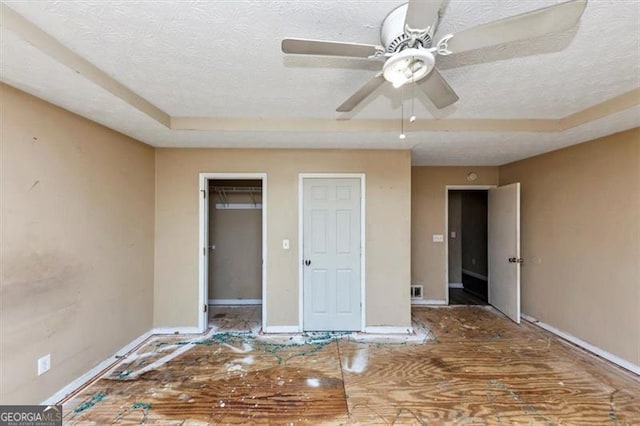 interior space featuring a tray ceiling, baseboards, and a textured ceiling